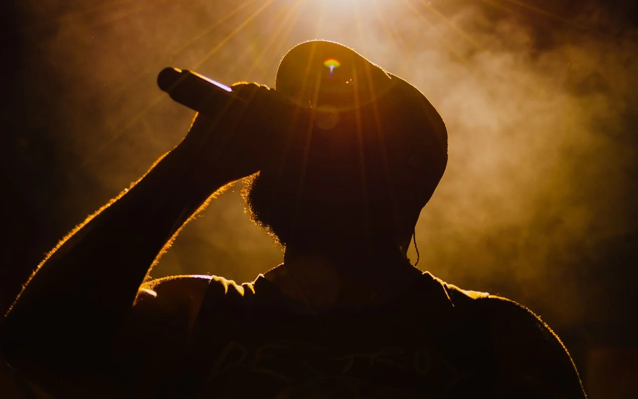 Punjabi singer performing with a microphone under stage lights